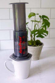 Photo of an AeroPress on a mug on a kitchen counter.